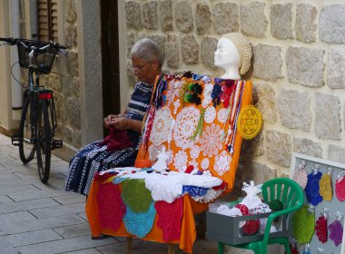 Pag, Hırvatistan, 2 Eylül 2023. Dantel yapıp turistlere satan bir kadın.