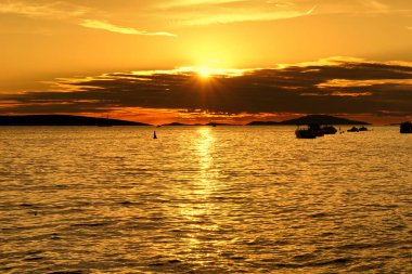 Yaz boyunca deniz kıyısındaki küçük limanda altın rengi gün batımı