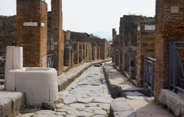 İtalya, Pompeii, 14 Haziran 2023. Pompei şehir sokağında eski tuğlaların arasında büyük beyaz taşlar.