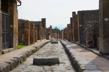 İtalya, Pompeii, 14 Haziran 2023. Pompeii 'nin turistik bölgesinde duvarları ve kalıntıları olan taştan bir sokak.
