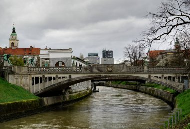 Ljubljana, Slovenya - 29 Mart 2024. Ljubljana 'daki ünlü Ejderha Köprüsü manzarası, altında Ljubljanica Nehri akıyor.