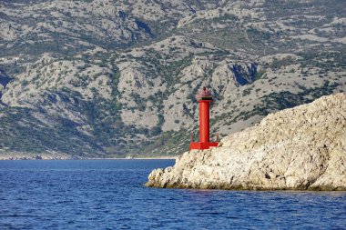 Deniz feneri kıyı ve ada arasındaki küçük taşlı adanın bir parçası.