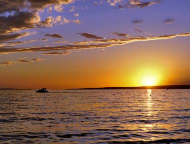 Sahilde mavi saat boyunca parlak ve parlak altın gün batımı