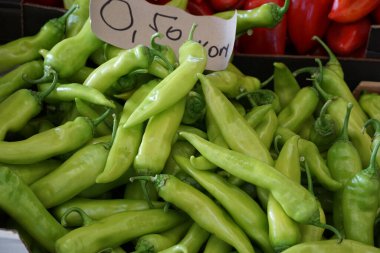 Fruits of domestic sweet green peppers on the table of the city market clipart