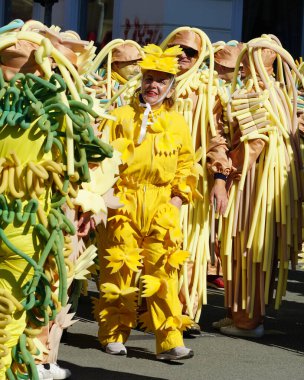 Rijeka, Hırvatistan, 2 Mart 2025. Karnaval geçidinde sarı makarna kostümlü komik yaşlı kadın.