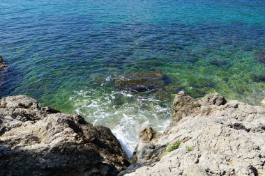 Hırvatistan 'ın deniz kıyısındaki deniz koyundaki mavi ve turkuaz dalgalı denize hava manzarası