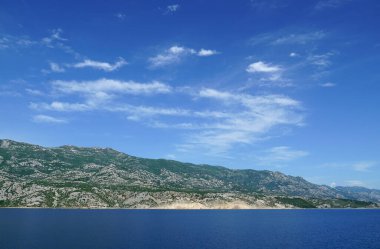 Hırvatistan 'ın en büyük dağı olan Velebit' in altındaki anakaranın bir kısmı, deniz kanalında yüzen bir feribottan manzaralı.