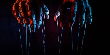 Kontrol için iplikleri olan şeytanın metaforik pençeleri.