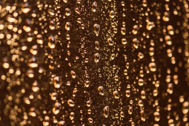 Doku damlaları altın yüzeyden aşağı akar.