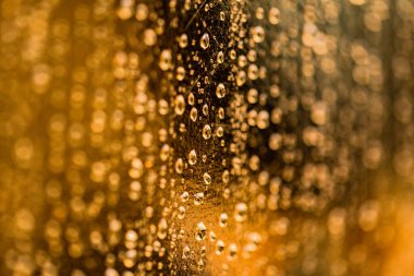 Doku damlaları altın yüzeyden aşağı akar.