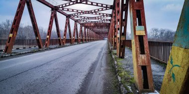 Dağ nehri üzerinde demir bir köprü.