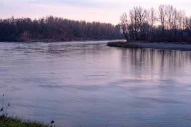 Gün batımında akan bir dağ nehrinin manzarası