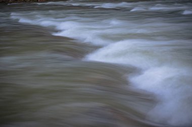 Akıntılı dağ nehri akıntılarda kükrüyor.