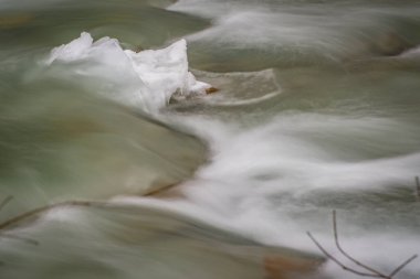 Mountain river with clear water from melting snow and ice