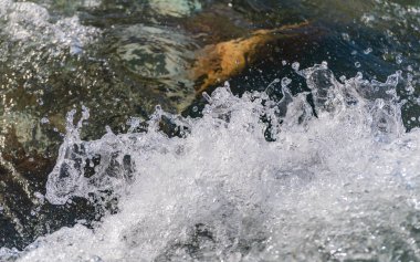 Mountain river with clear water from melting snow and ice