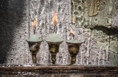 Şamdanın arkasında yağmurlu üç mum.