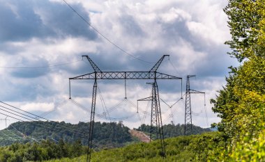 Fırtına bulutlarının arka planında yüksek voltajlı elektrik hatları