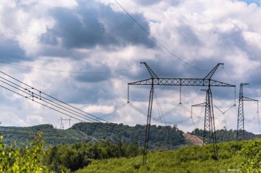 Fırtına bulutlarının arka planında yüksek voltajlı elektrik hatları