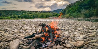 Dağ nehrinin kıyısında şenlik ateşi