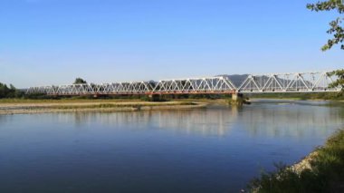 Dağ nehri üzerinde bir demiryolu köprüsü olan hızlandırılmış manzara.