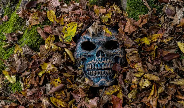 Düşen yapraklardan çıkan canavar maskesi.
