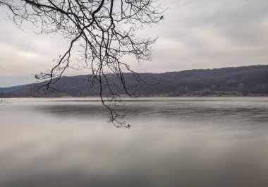 Bir dağ gölü üzerinde kış günbatımı manzarası