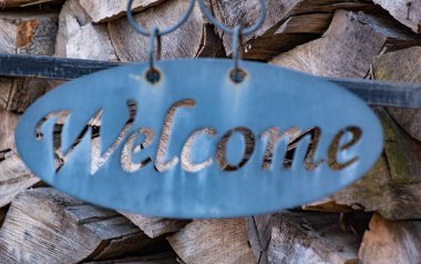 Odunların dizildiği bir arka planda hoş geldiniz işareti