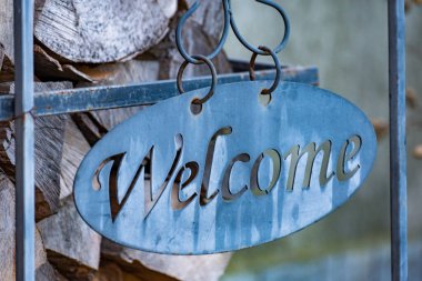 Odunların dizildiği bir arka planda hoş geldiniz işareti