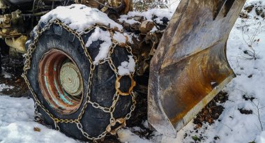 Dağ ormanlarında zincirlenmiş eski traktör.