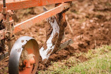 Eski bir traktör kırsal bir dağlık alanda toprağı sürüyor.