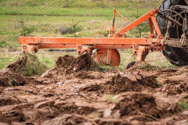 Eski bir traktör kırsal bir dağlık alanda toprağı sürüyor.