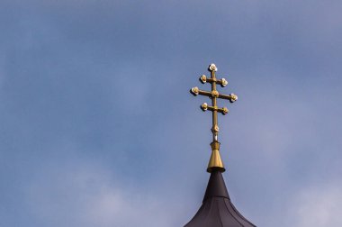 Baharda gökyüzünün arka planında kırsal bir kilisenin haçı olan manzara.