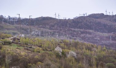 İlkbaharda dağlık bölgede yüksek voltajlı elektrik hatları