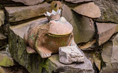 Parktaki terk edilmiş bir çeşmede kurbağa süslemesi.