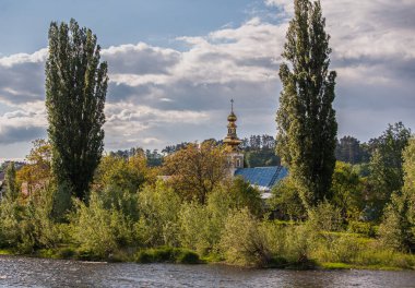 Kavak, kilise ve şatolu bir dağ nehrinin manzarası.