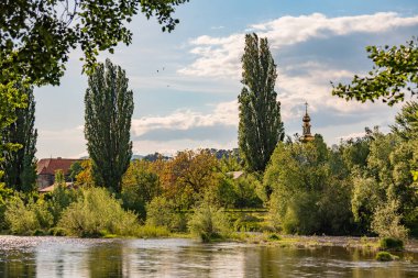 Kavak, kilise ve şatolu bir dağ nehrinin manzarası.