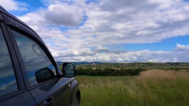 SUV ile dağlık kırsal bölgede yaz manzarasının zaman aşımı