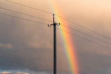 Gökkuşağı ve elektrik hatlarıyla sonbahar manzarası