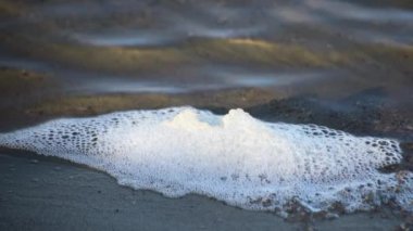 Gün batımında gölün şeffaf dalgaları