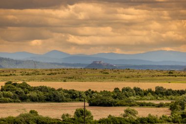 Uzakta antik şatosu olan bahar ovasının manzarası