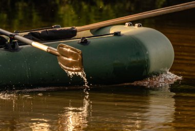 Lastik bir teknenin küreğinden su akar.