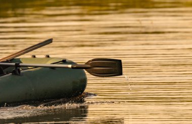 Lastik bir teknenin küreğinden su akar.