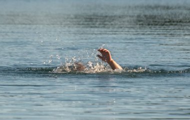Boğulan adamın elleri su yüzeyinde.