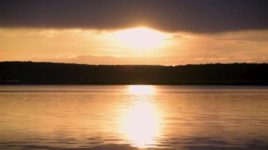 Yazın gün batımında fırtınadan önceki bir göl manzarası.
