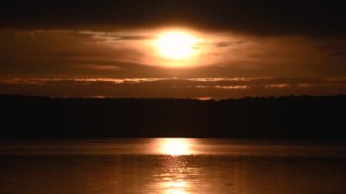 Yazın gün batımında fırtınadan önceki bir göl manzarası.