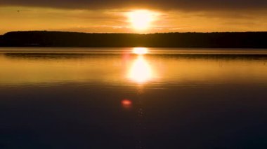 Yazın gün batımında fırtınadan önceki bir göl manzarası.