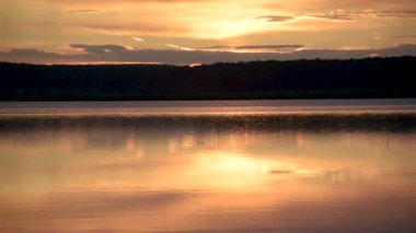 Yazın gün batımında fırtınadan önceki bir göl manzarası.