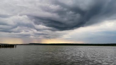 Yazın gün batımında fırtınadan önceki bir göl manzarası.