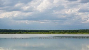 Gün batımında fırtınadan önce bir göl manzarasının zamanaşımı