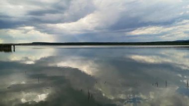 Gün batımında fırtınadan önce bir göl manzarasının zamanaşımı